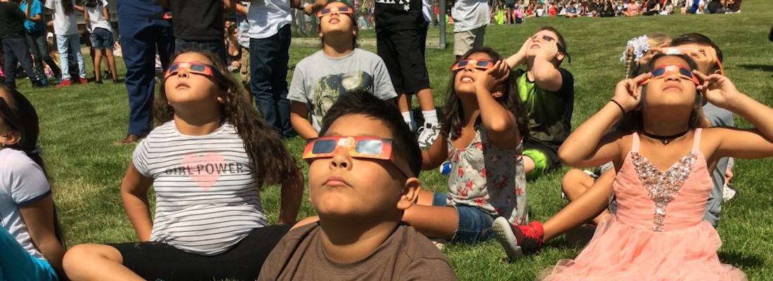 Students wearing glasses looking at the sky